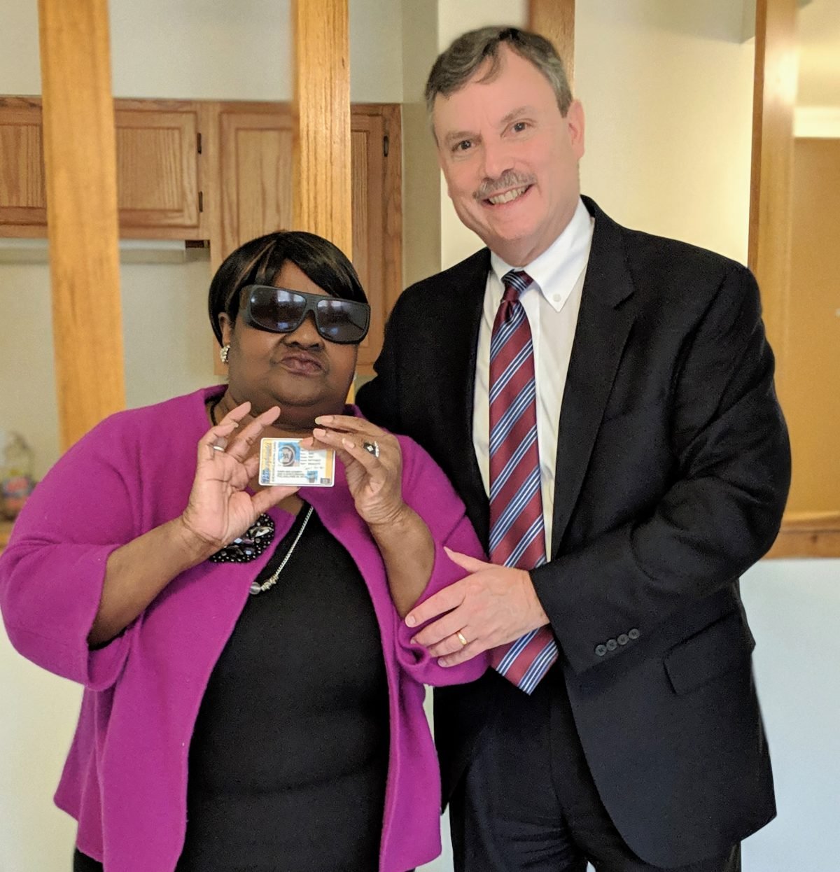 Client, with her volunteer attorney, holding her new photo ID.